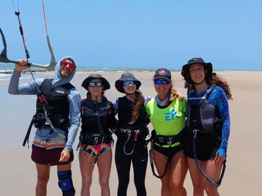 Students in harnesses gathered on the beach before a lesson