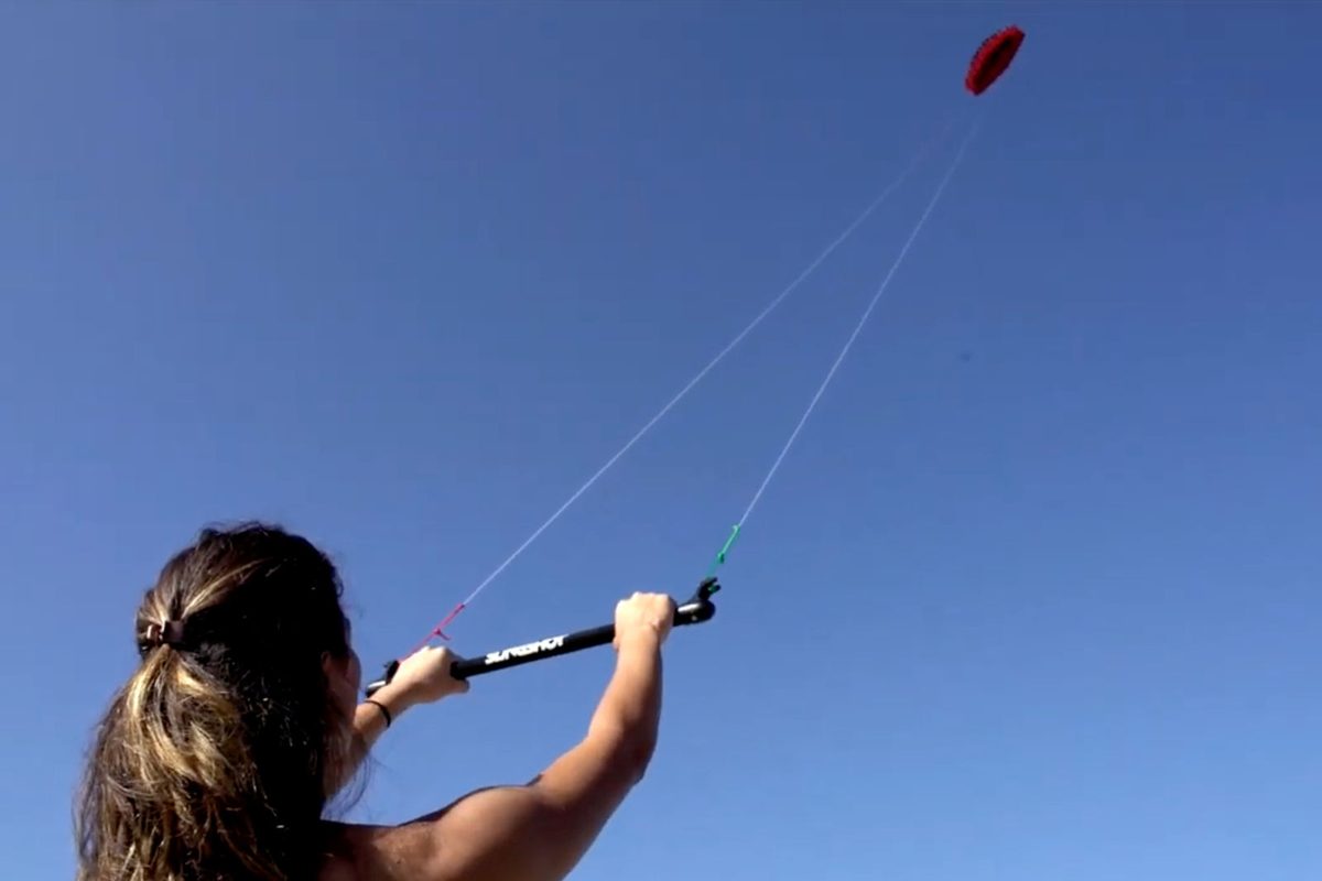 Student flying a trainer kite on the beach during an EK Experience discovery session